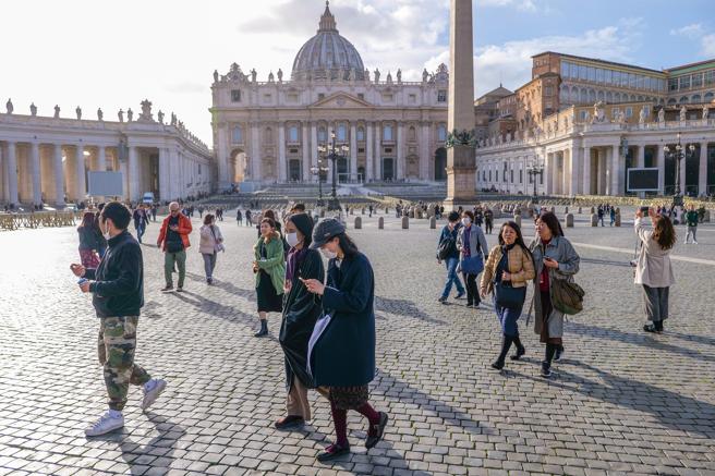 Un grupo de turistas asiaticos camina en una plaza de San Pedro del Vaticano muy desierta, en febrero pasado