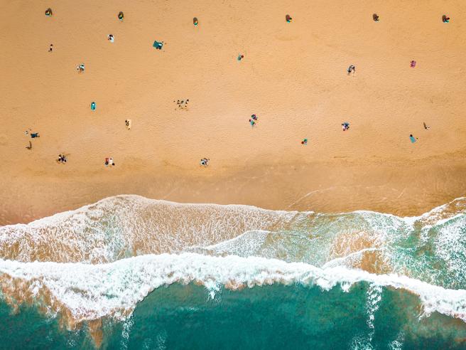 Vista aérea de una playa con gente respetando la distancia de dos metros o más entre ellos
